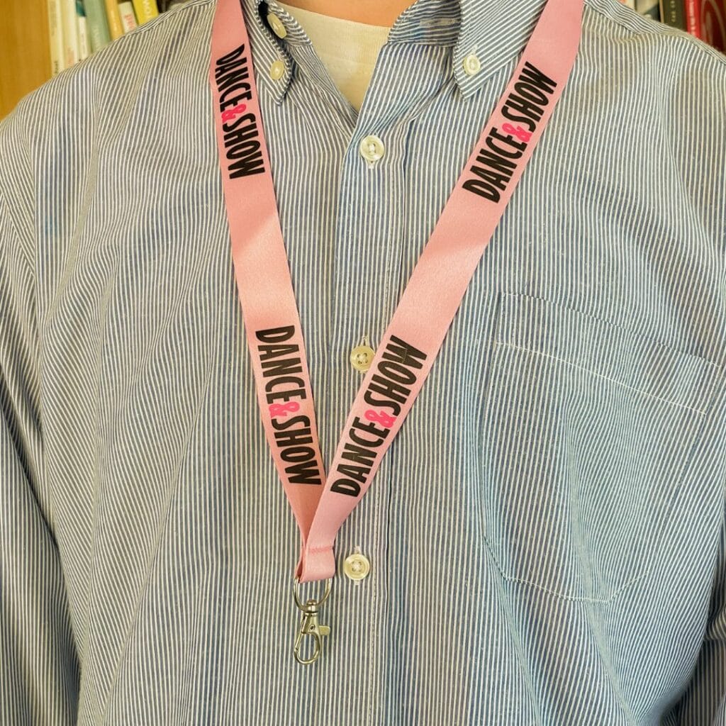 lanyard personalizado color rosa colgado en el cuello de un hombre