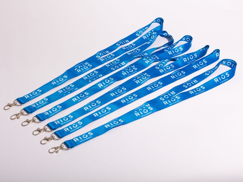 Varios lanyards personalizados baratos comprados online de color azul con clips metálicos, perfectos para eventos corporativos en España.